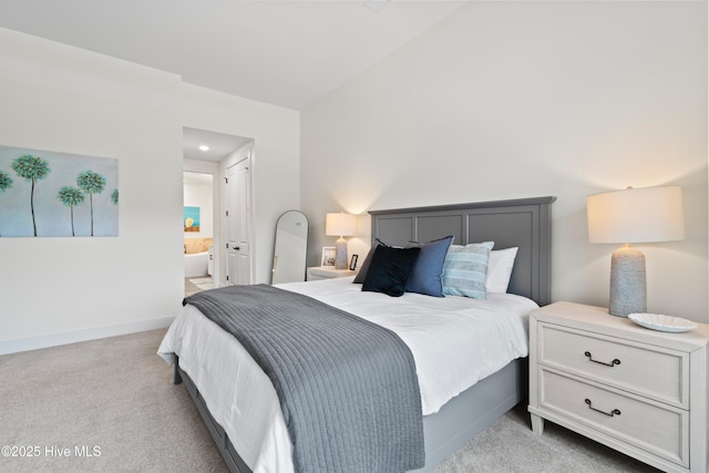 bedroom featuring light carpet and ensuite bath