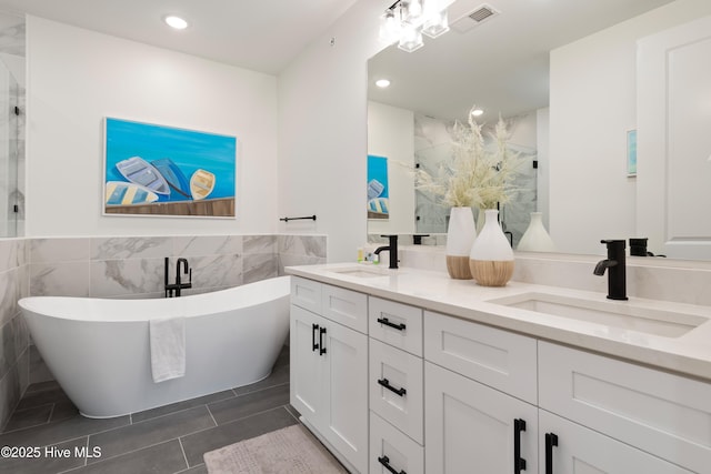 bathroom featuring vanity, a bathing tub, tile patterned flooring, and tile walls