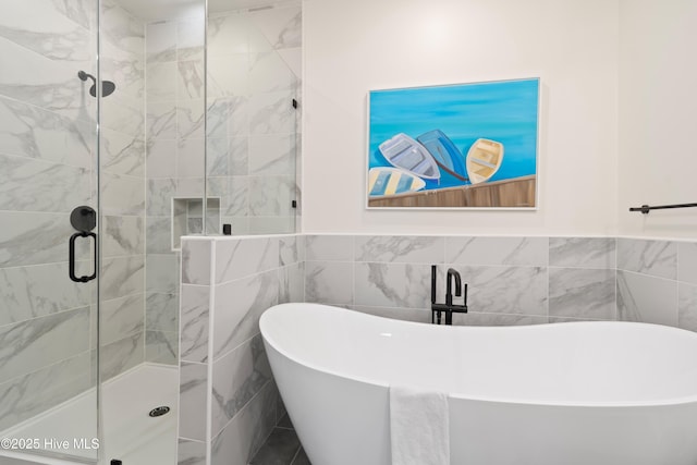 bathroom featuring separate shower and tub and tile walls