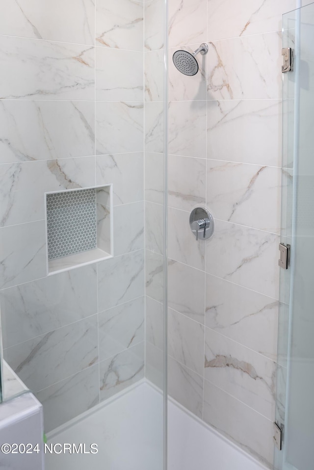 bathroom featuring a shower with shower door