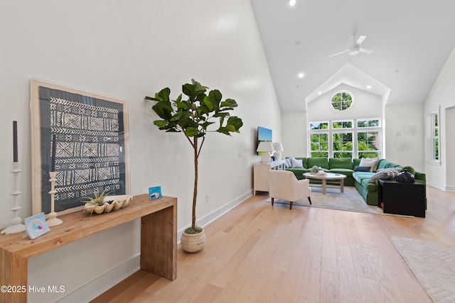 living room with ceiling fan, high vaulted ceiling, and light hardwood / wood-style floors