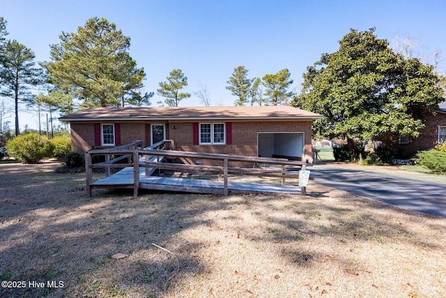 view of front of home with brick siding and a wooden deck