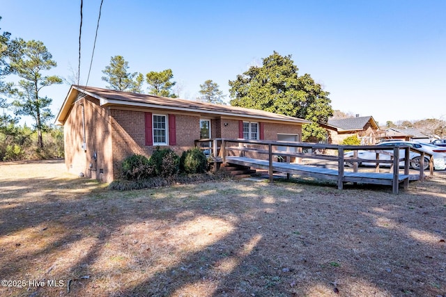 view of front of home featuring a deck and brick siding