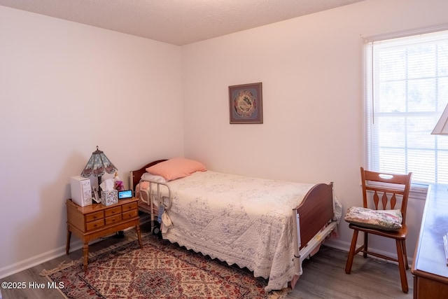 bedroom with baseboards and wood finished floors