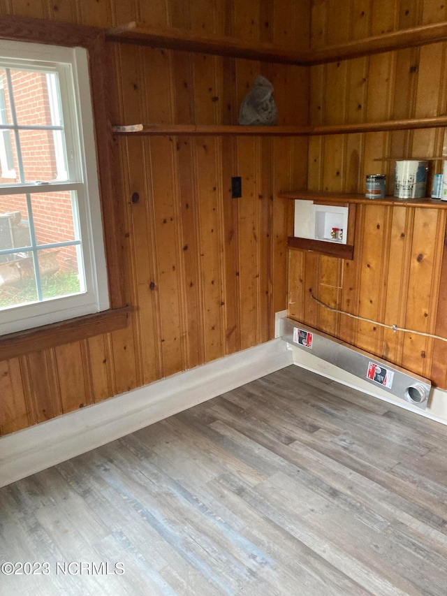 laundry room featuring wooden walls, light wood-type flooring, and hookup for a washing machine