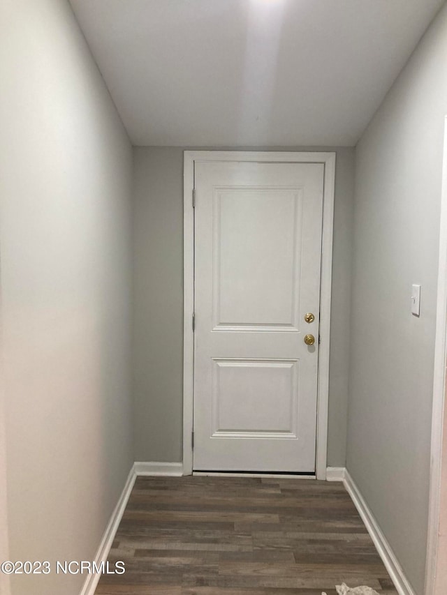 doorway to outside with dark wood-style floors and baseboards