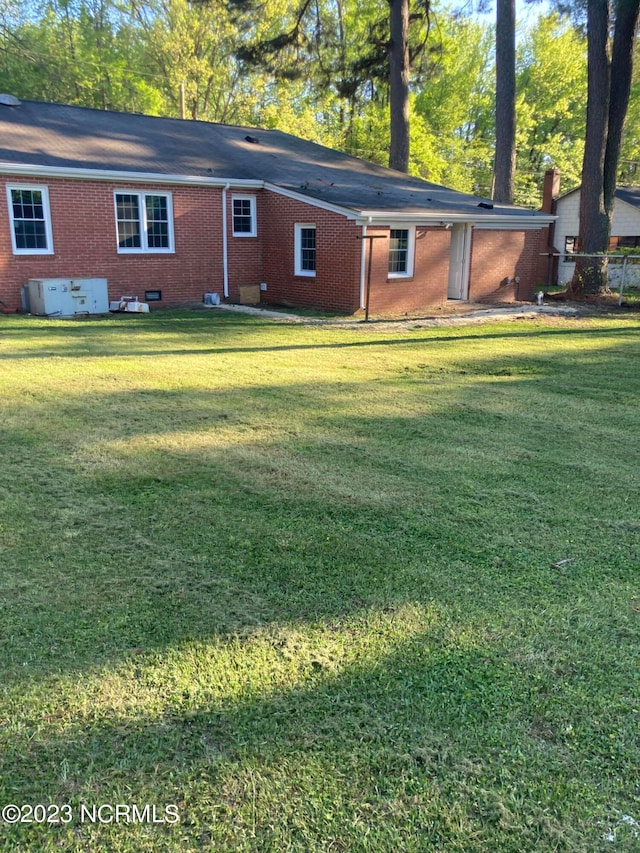 rear view of house featuring a lawn