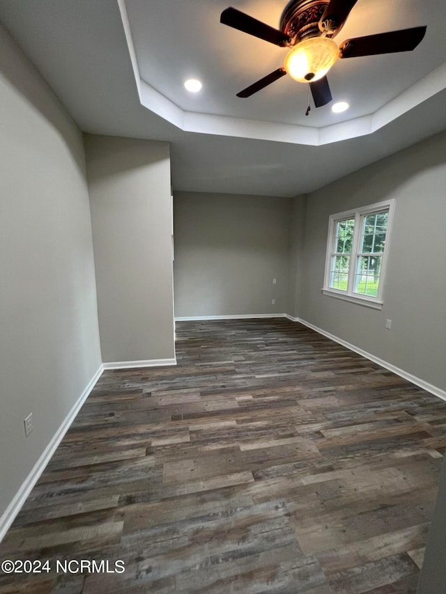 unfurnished room featuring ceiling fan, a raised ceiling, and hardwood / wood-style floors