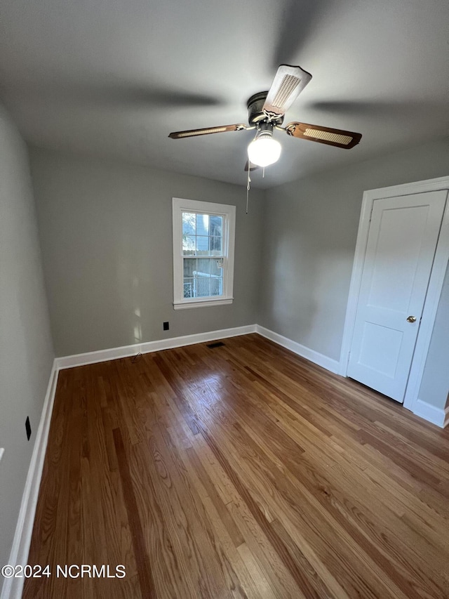 unfurnished bedroom featuring wood finished floors, visible vents, and baseboards