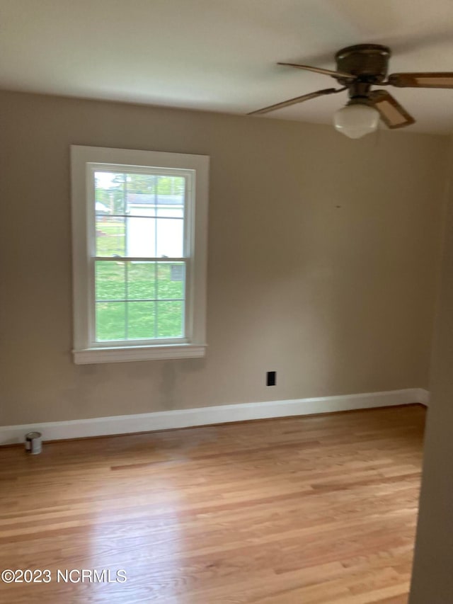 unfurnished room featuring light wood-type flooring, baseboards, and a ceiling fan