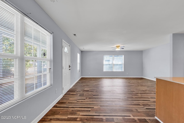 empty room with dark hardwood / wood-style flooring and a healthy amount of sunlight