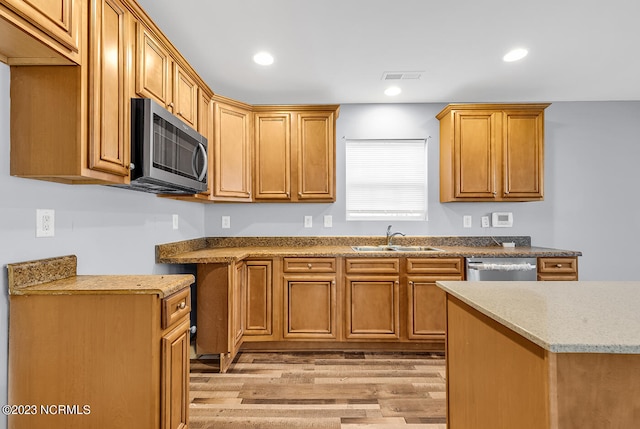 kitchen featuring light stone counters, light hardwood / wood-style flooring, sink, and stainless steel appliances