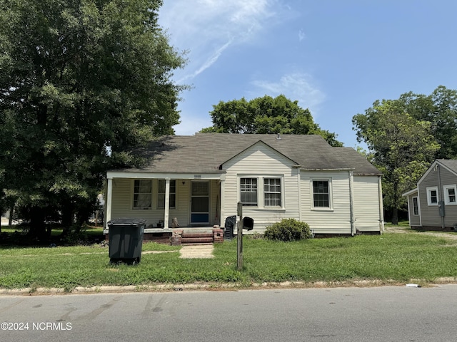 view of front of house with a porch and a front yard