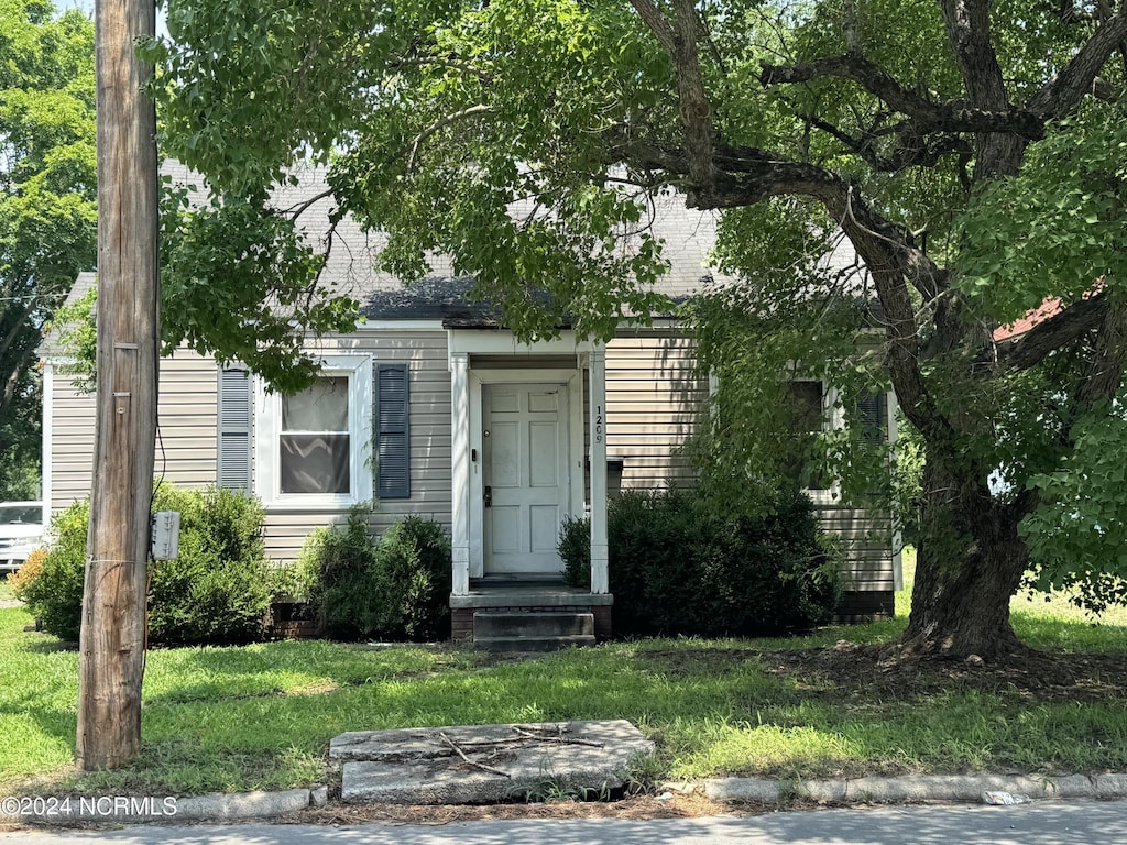 view of front of property featuring a front yard and roof with shingles