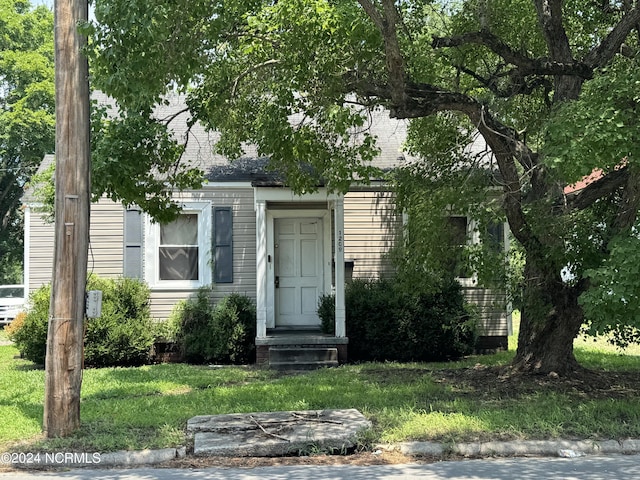 view of front of property featuring a front yard and roof with shingles