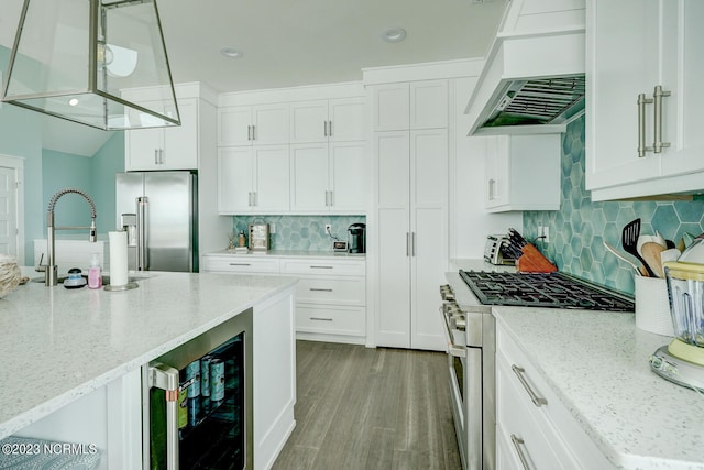 kitchen featuring light stone counters, high end appliances, premium range hood, wine cooler, and tasteful backsplash