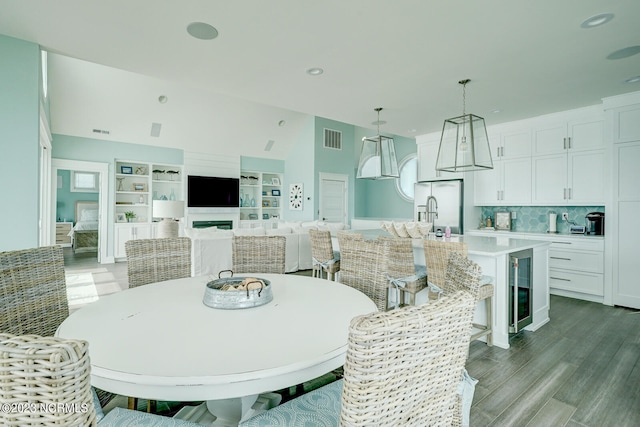 dining room featuring built in features, beverage cooler, and hardwood / wood-style flooring