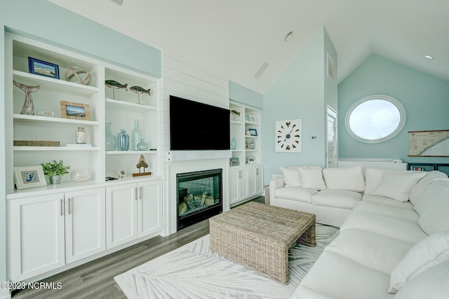 living room with high vaulted ceiling, built in features, and hardwood / wood-style floors