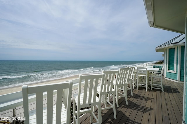 balcony with a water view and a view of the beach