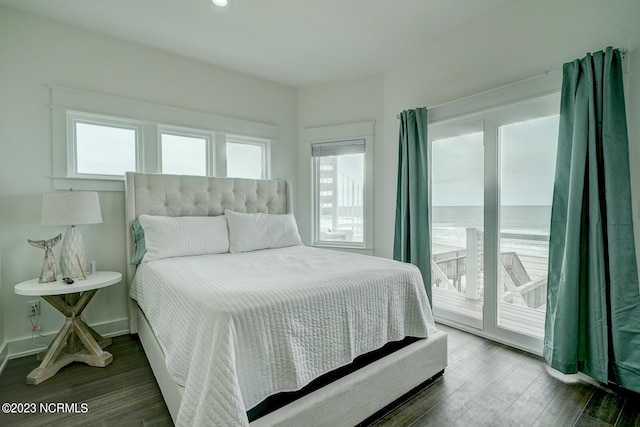 bedroom featuring a water view, access to outside, and dark wood-type flooring