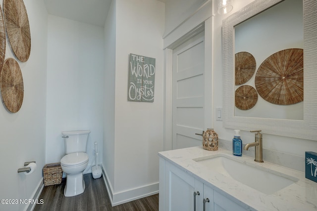 bathroom with oversized vanity, toilet, and wood-type flooring