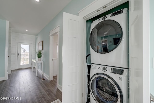 clothes washing area featuring stacked washer / dryer and dark hardwood / wood-style floors