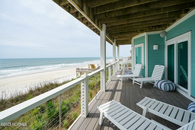 balcony with a water view and a view of the beach