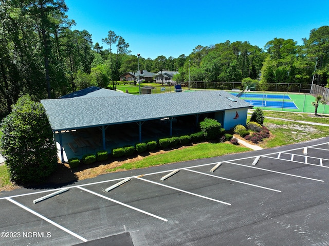 view of vehicle parking with tennis court