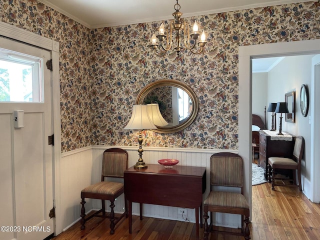 living area featuring ornamental molding, a notable chandelier, and light hardwood / wood-style flooring