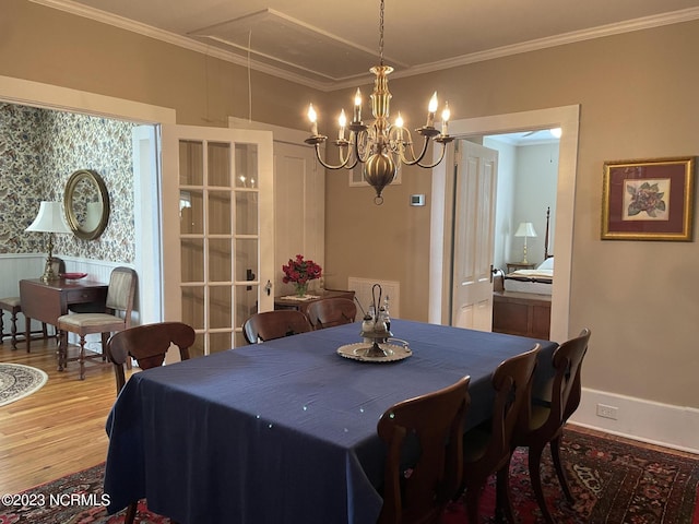 dining area with an inviting chandelier, crown molding, and hardwood / wood-style flooring