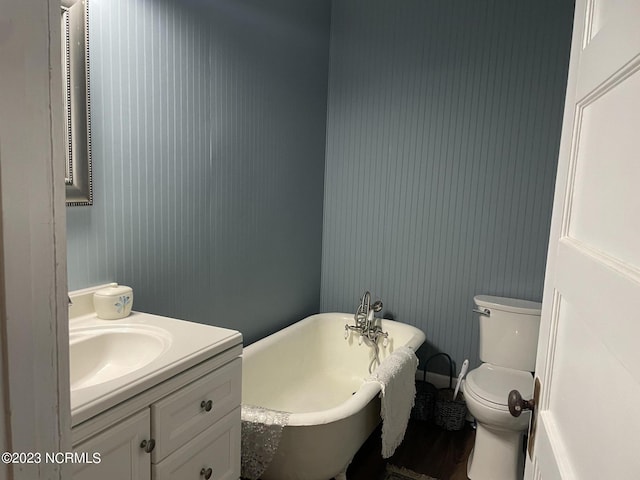 bathroom featuring a bath, hardwood / wood-style flooring, toilet, and vanity