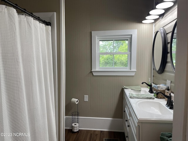 bathroom featuring hardwood / wood-style floors and vanity with extensive cabinet space