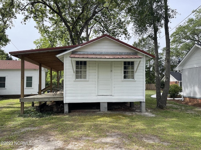 rear view of house featuring a lawn and an outdoor structure