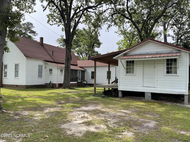 rear view of property featuring a lawn