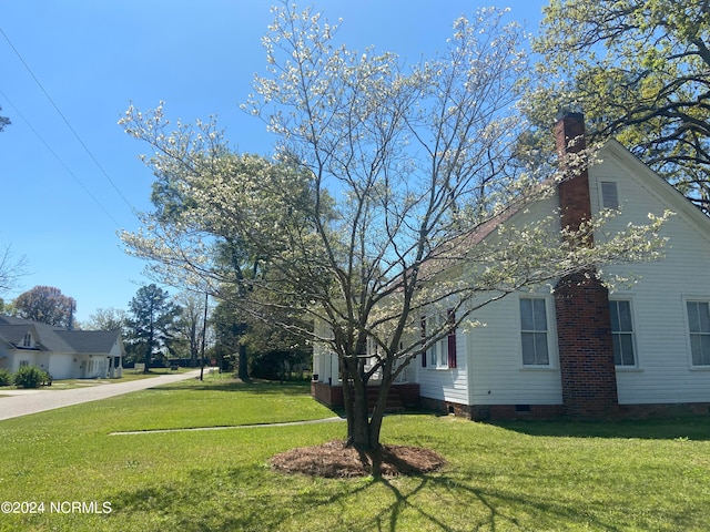 view of side of home with a yard