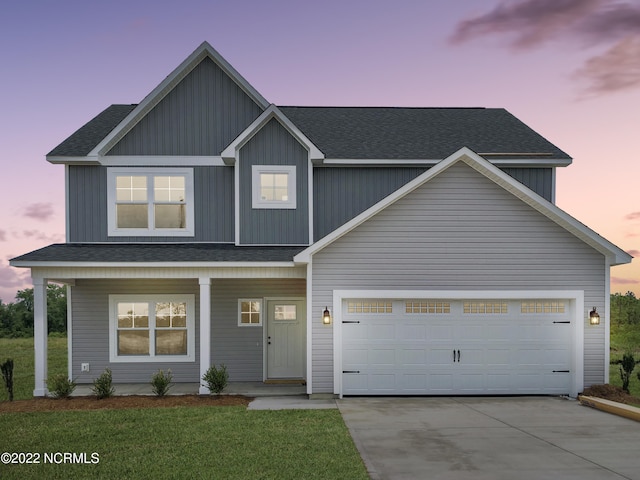 view of front of property featuring a garage and a lawn