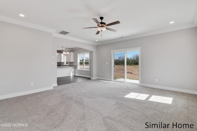 interior space with ceiling fan with notable chandelier, dark carpet, and ornamental molding