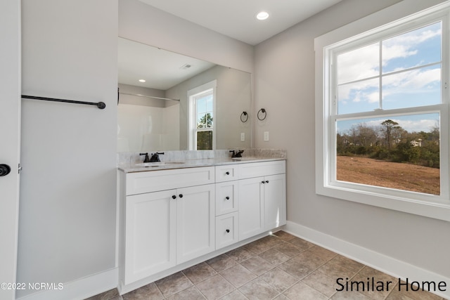 bathroom featuring oversized vanity, double sink, and tile flooring