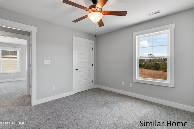 unfurnished room with ceiling fan and carpet flooring