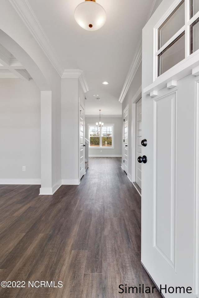 interior space featuring dark hardwood / wood-style flooring, crown molding, and an inviting chandelier