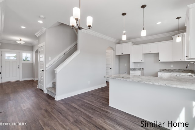 kitchen featuring dark wood-type flooring, hanging light fixtures, and white cabinets