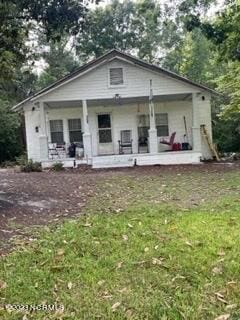 rear view of property featuring covered porch