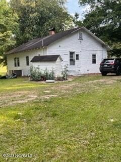 rear view of property with a lawn