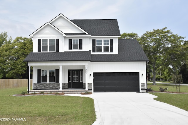 view of front of house featuring a garage, a porch, and a front yard