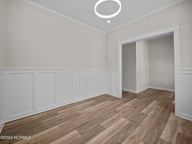 spare room with ornamental molding and light hardwood / wood-style floors