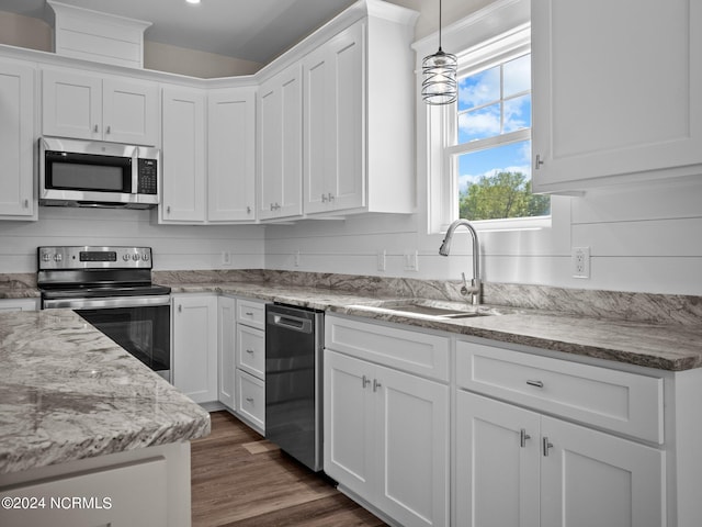 kitchen with white cabinetry, appliances with stainless steel finishes, light stone countertops, and sink