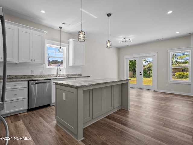 kitchen with dark wood-type flooring, white cabinetry, decorative light fixtures, dishwasher, and a kitchen island