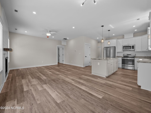 kitchen with white cabinetry, decorative light fixtures, light hardwood / wood-style flooring, appliances with stainless steel finishes, and a kitchen island