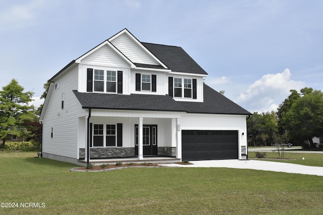 view of front facade with a garage, covered porch, and a front lawn