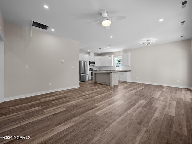 unfurnished living room featuring wood-type flooring and ceiling fan